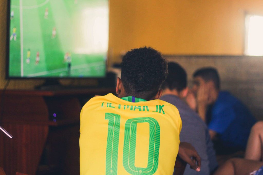A person watching a Brazil soccer game with a Neymar jersey on