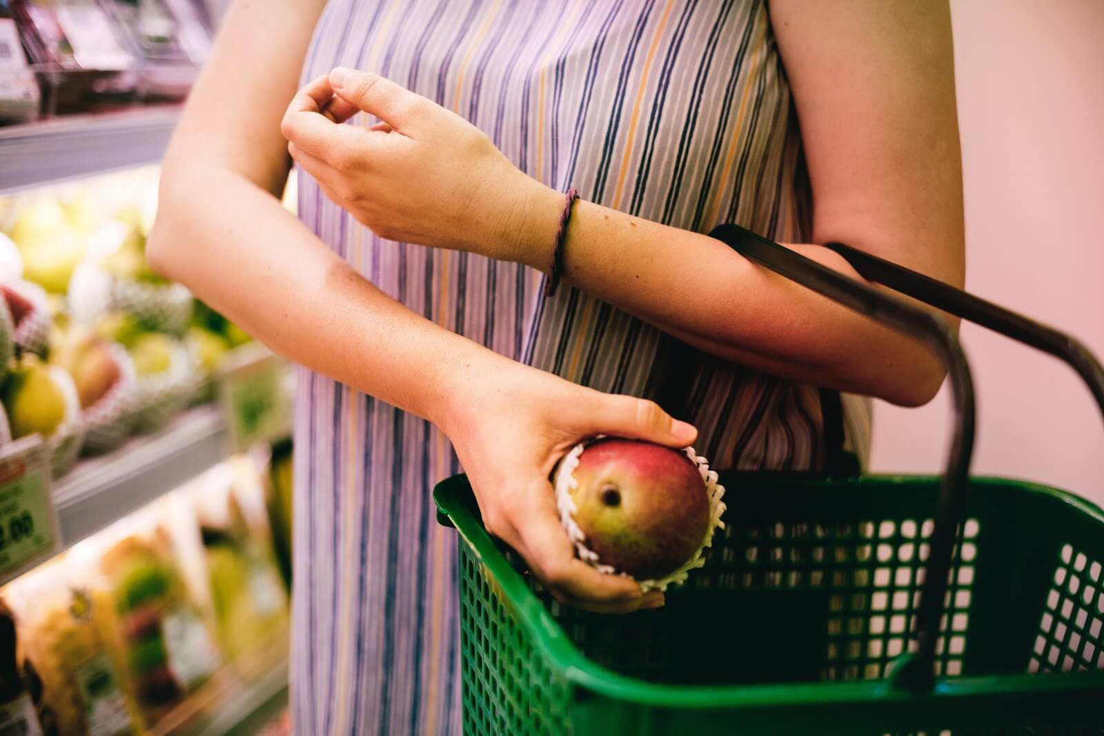 Woman using the Instacart shopper app to select produce