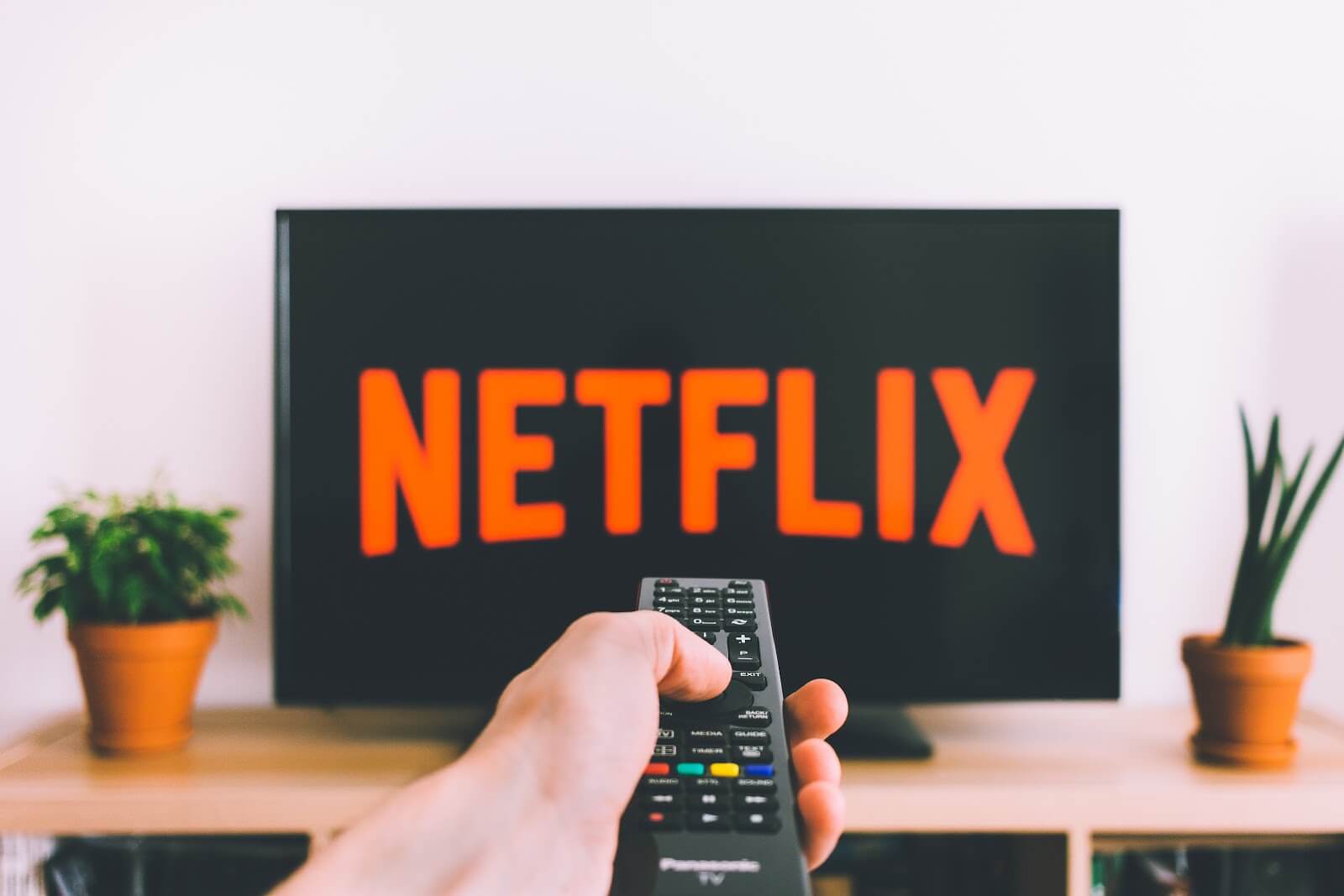 Online jobs: Remote pointing at TV screen with Netflix logo
