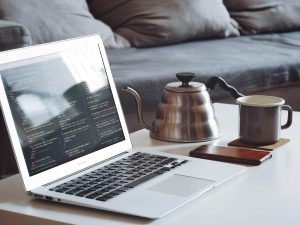 Online jobs: Laptop on coffee table with tea kettle