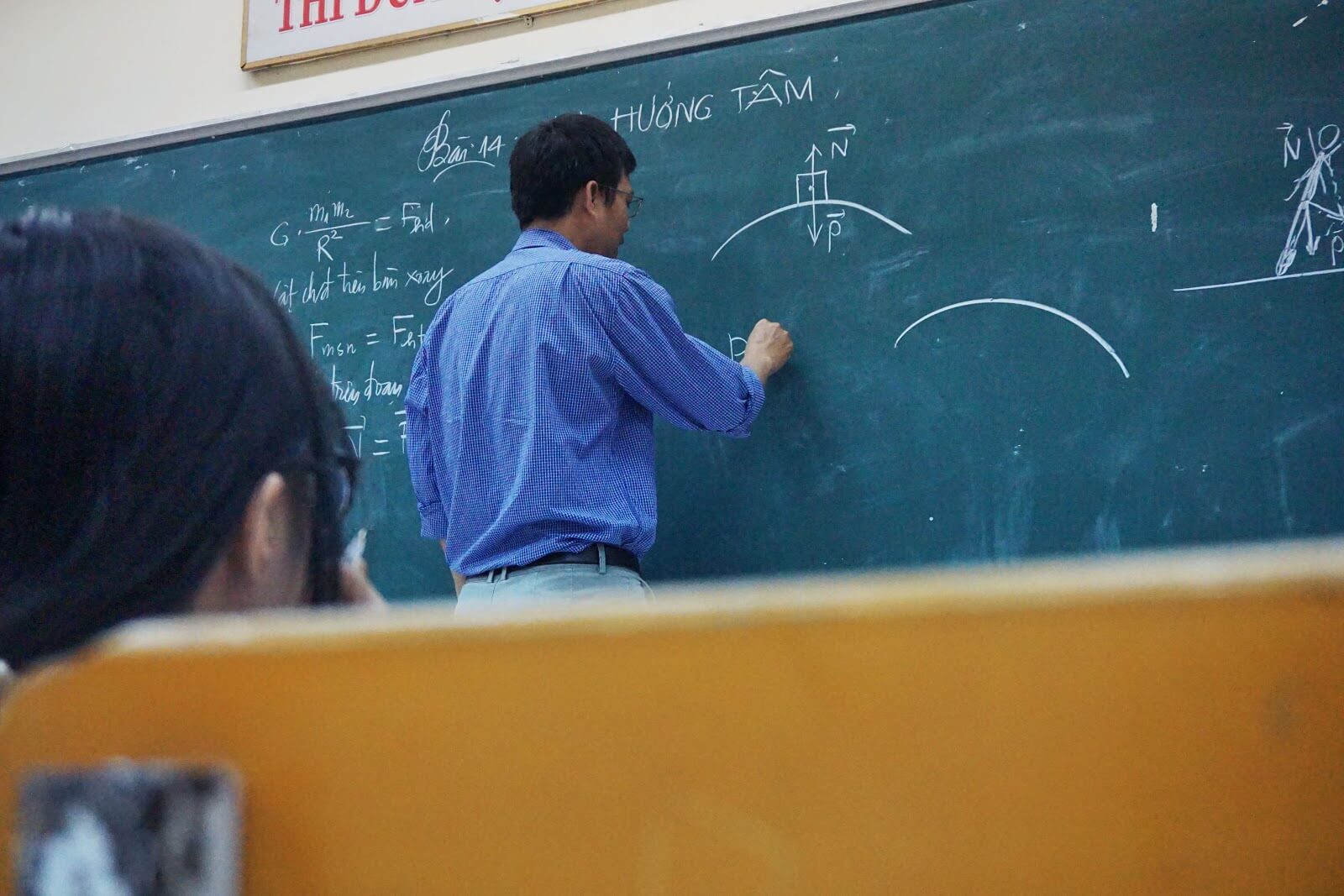 Online Tutoring Jobs: Man writing on chalkboard in classroom