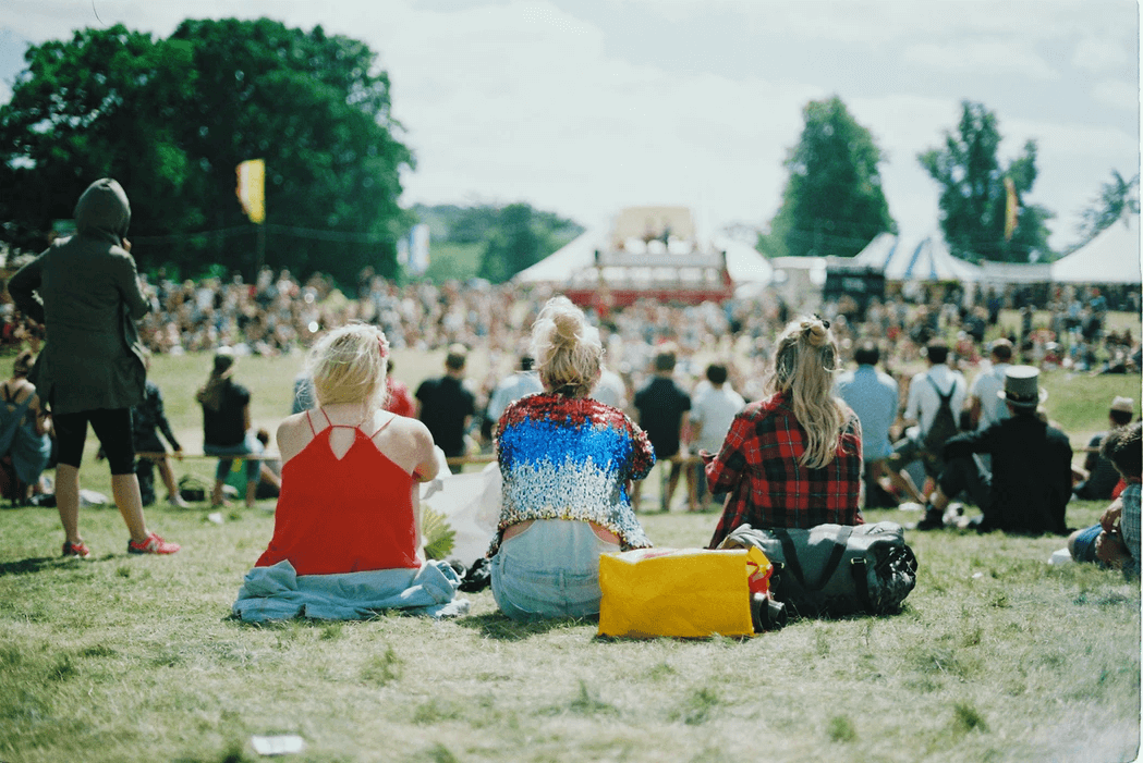 Three girls sitting at festival