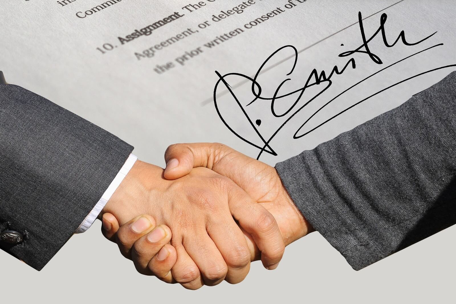 Articles of incorporation: Two men shake hands in front of a signed document