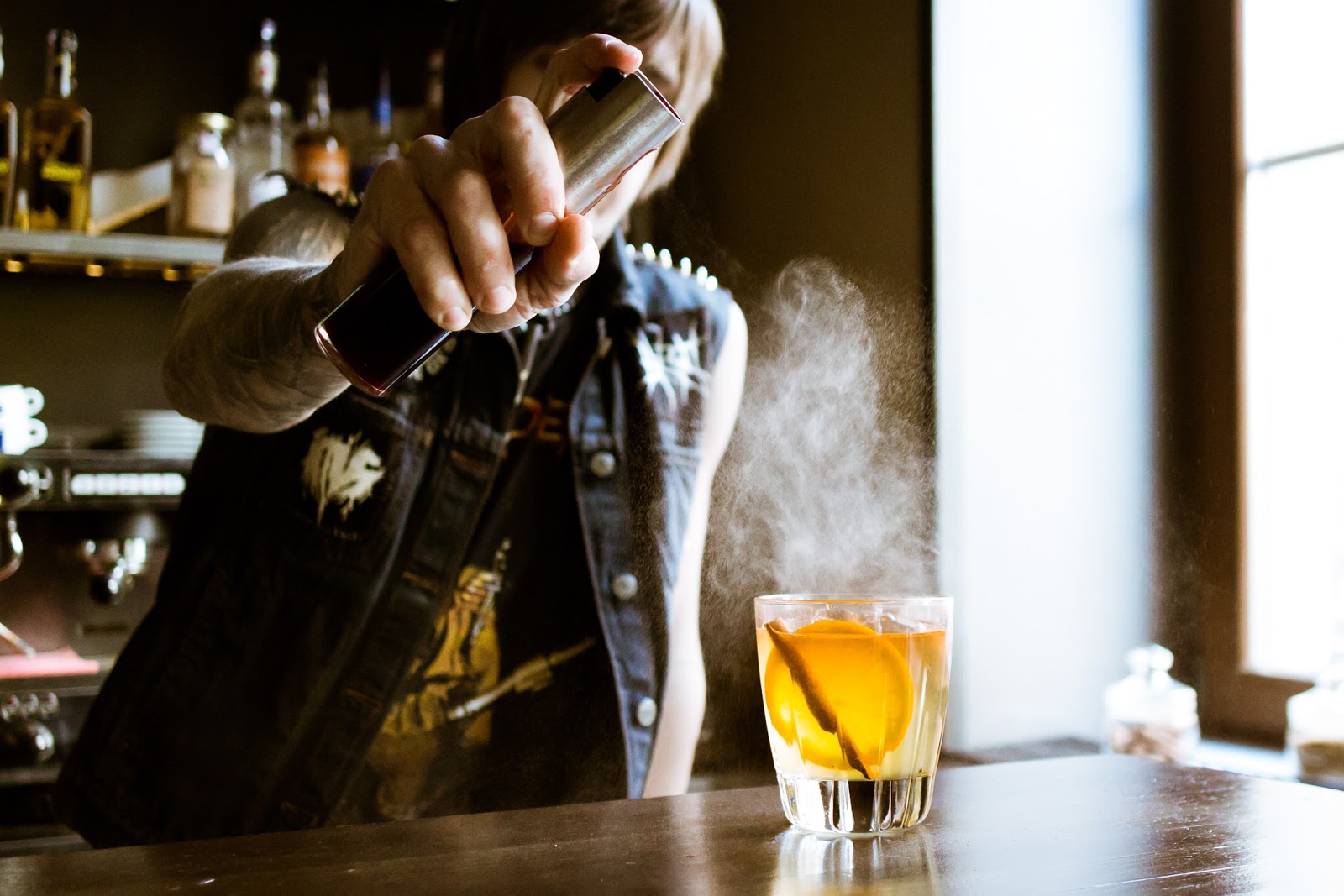 Bartender spritzing an artisanal cocktail