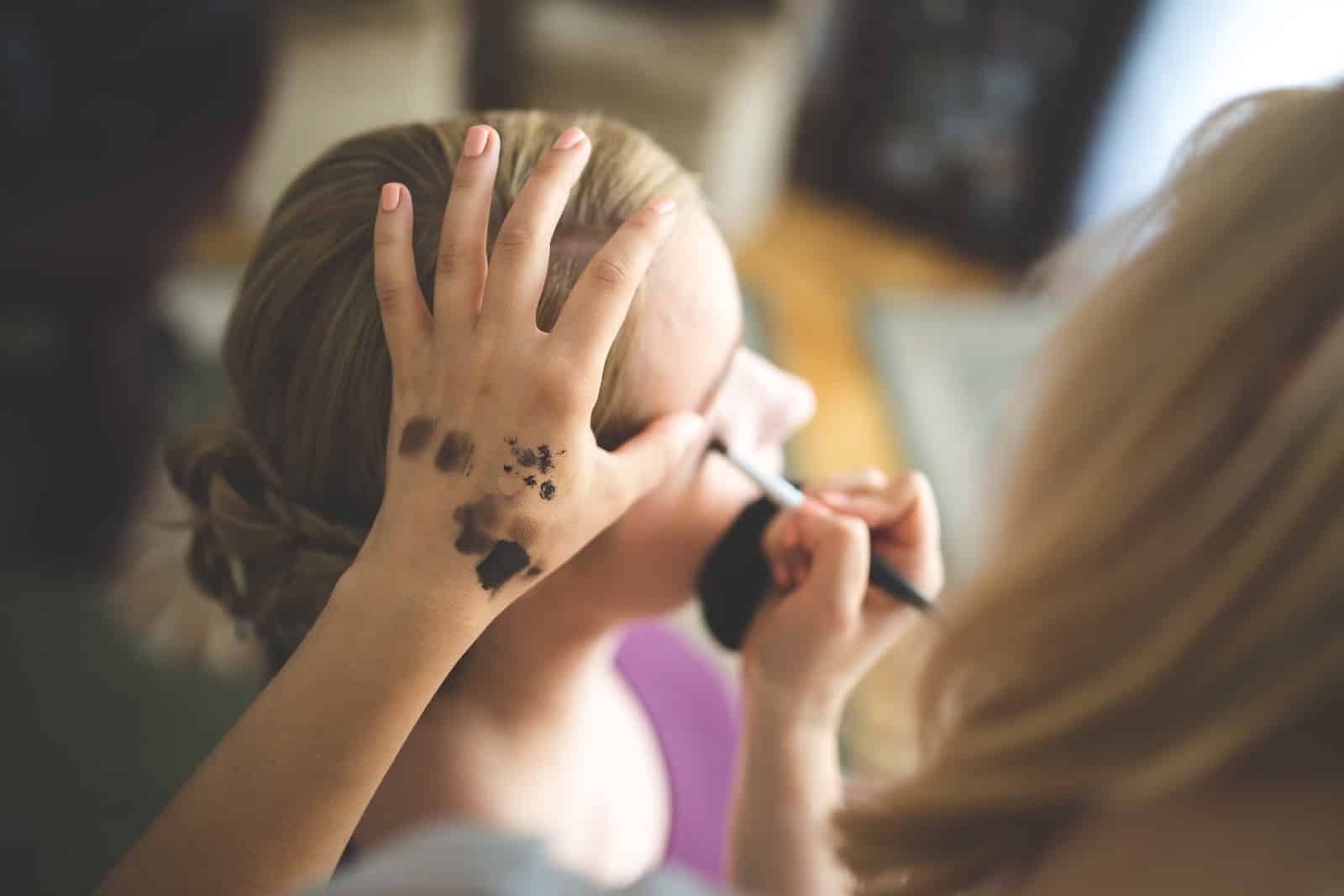A makeup artist works on a client