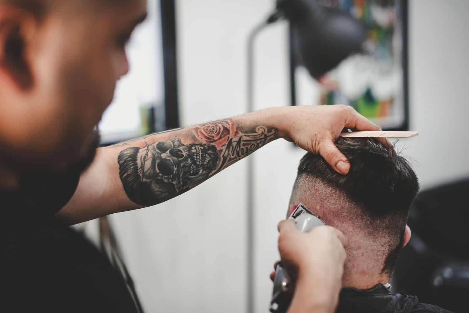 A barber shaves a man's head