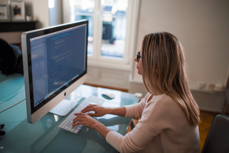 A side view of female Software Developer wearing eyeglasses during her work