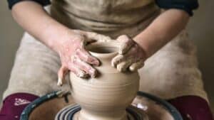 image showing a man crafting a piece of pottery on a pottery wheel - header graphic for the hobby ideas post on gigworker.com